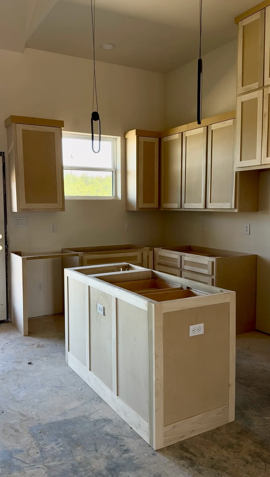 Same kitchen before completion, with unfinished cabinetry and island